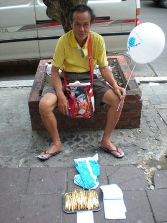 Holding a balloon and selling pens