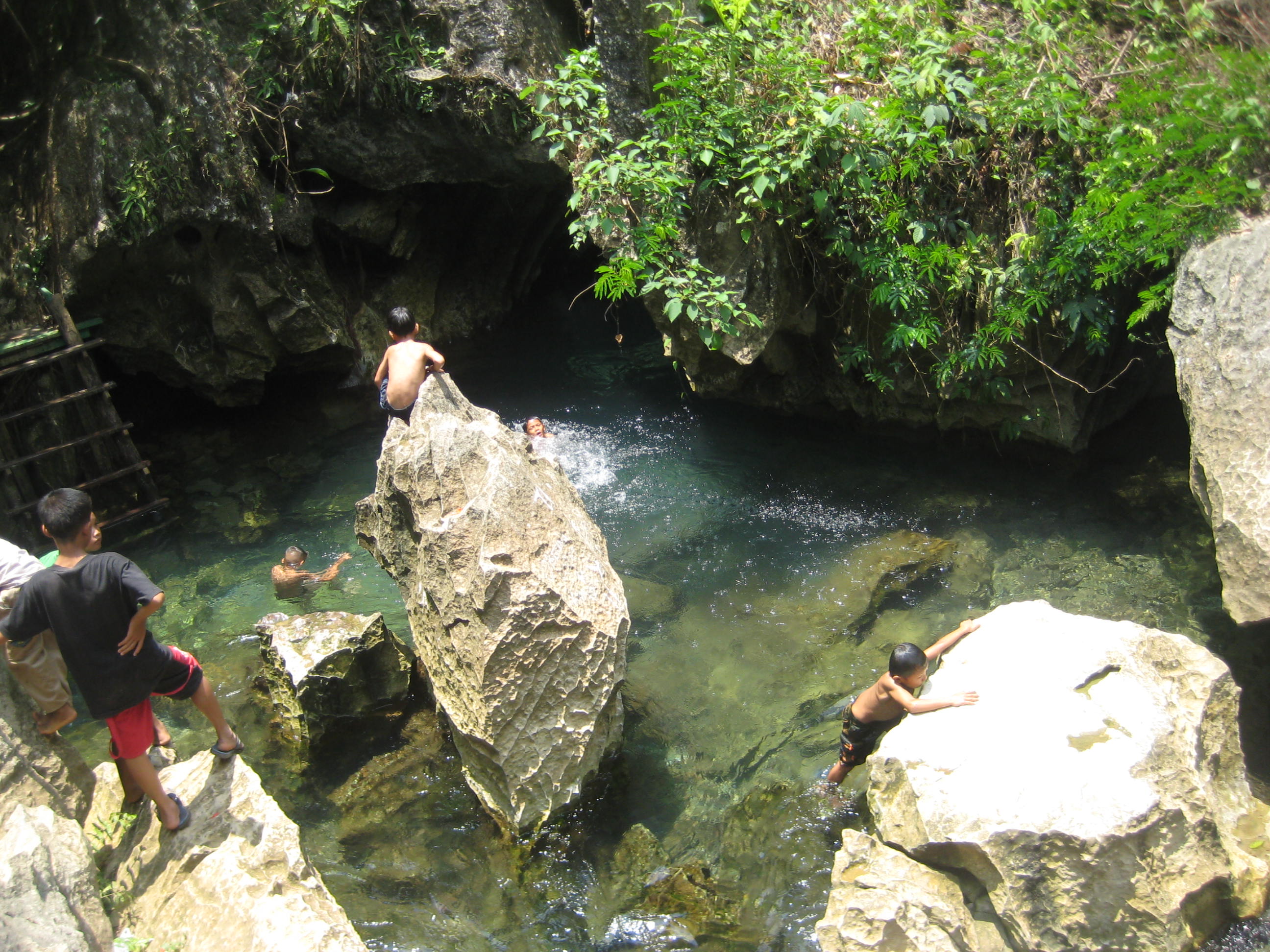 Boys play in Tham Jang Cave lagoon