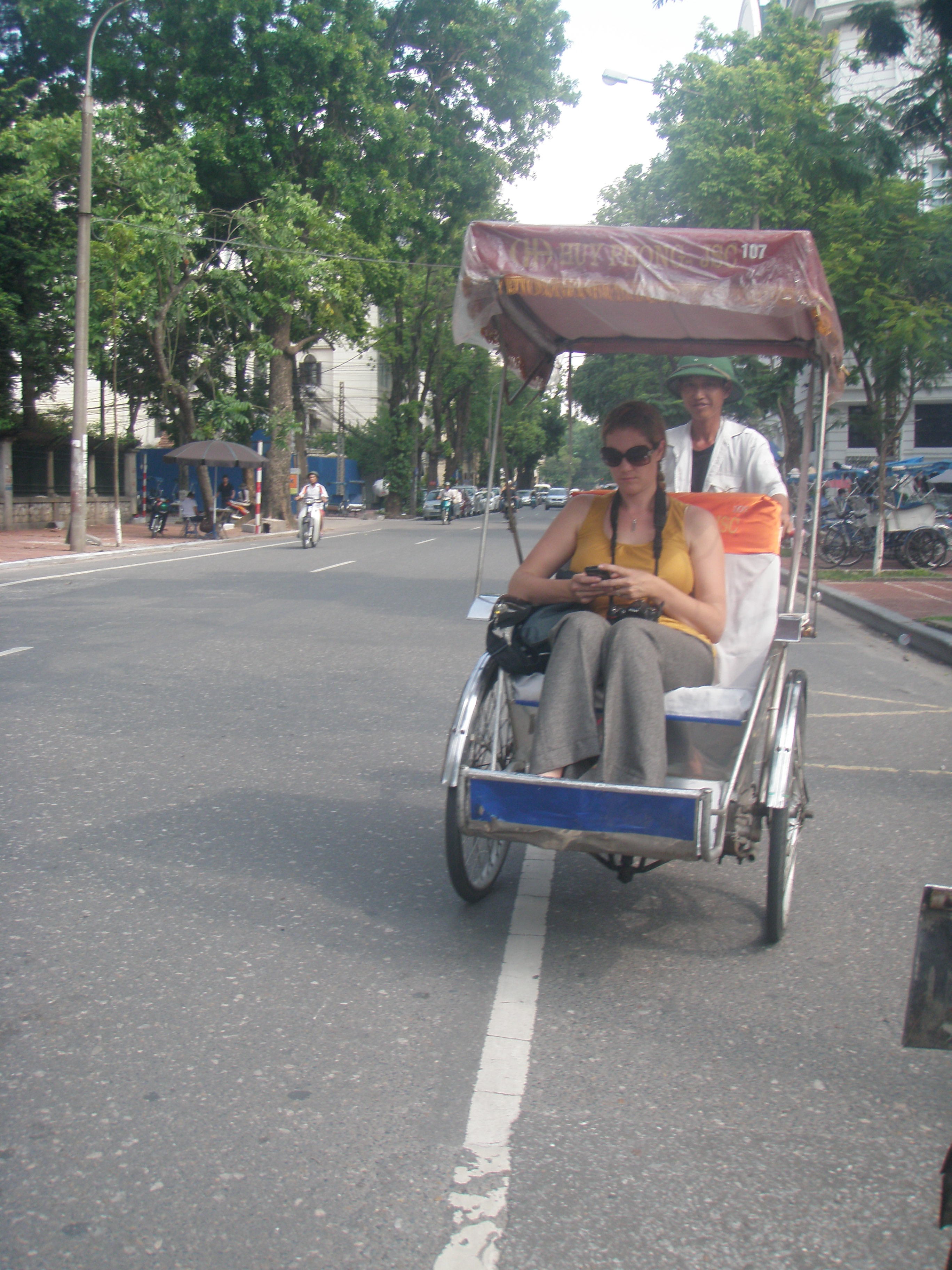 Yep, Andrea really is checking her Blackberry while on a Cyclo tour in Hanoi.